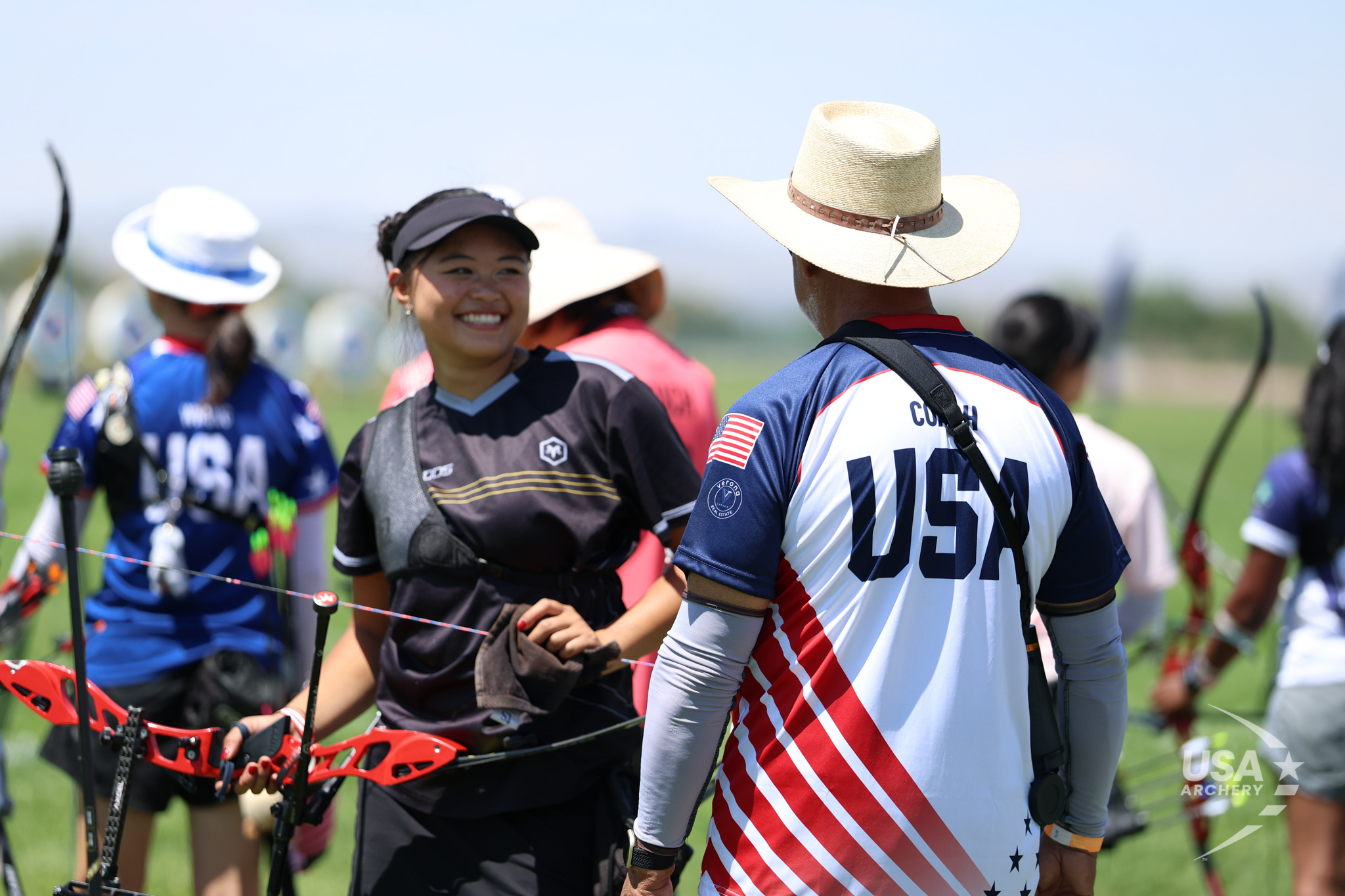 An archer and a USA Archery coach sharing a moment on the competition field